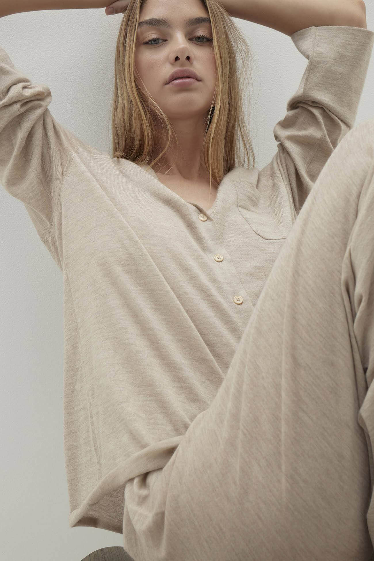 Woman in beige loungewear top and pants, showcasing comfortable and stylish Tops for relaxing at home.