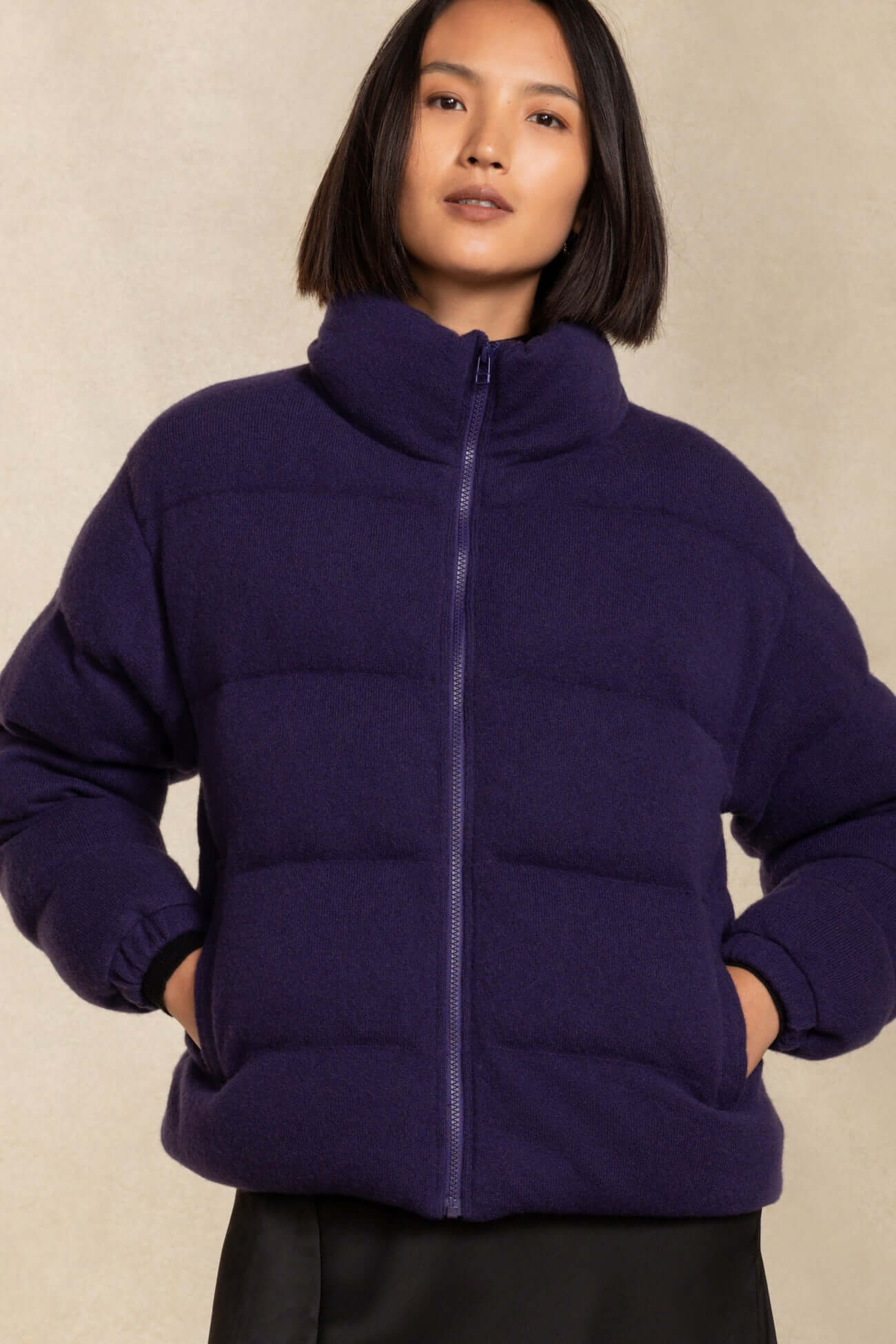Model wearing a stylish purple outerwear jacket with a zip and high collar, perfect for cold weather.