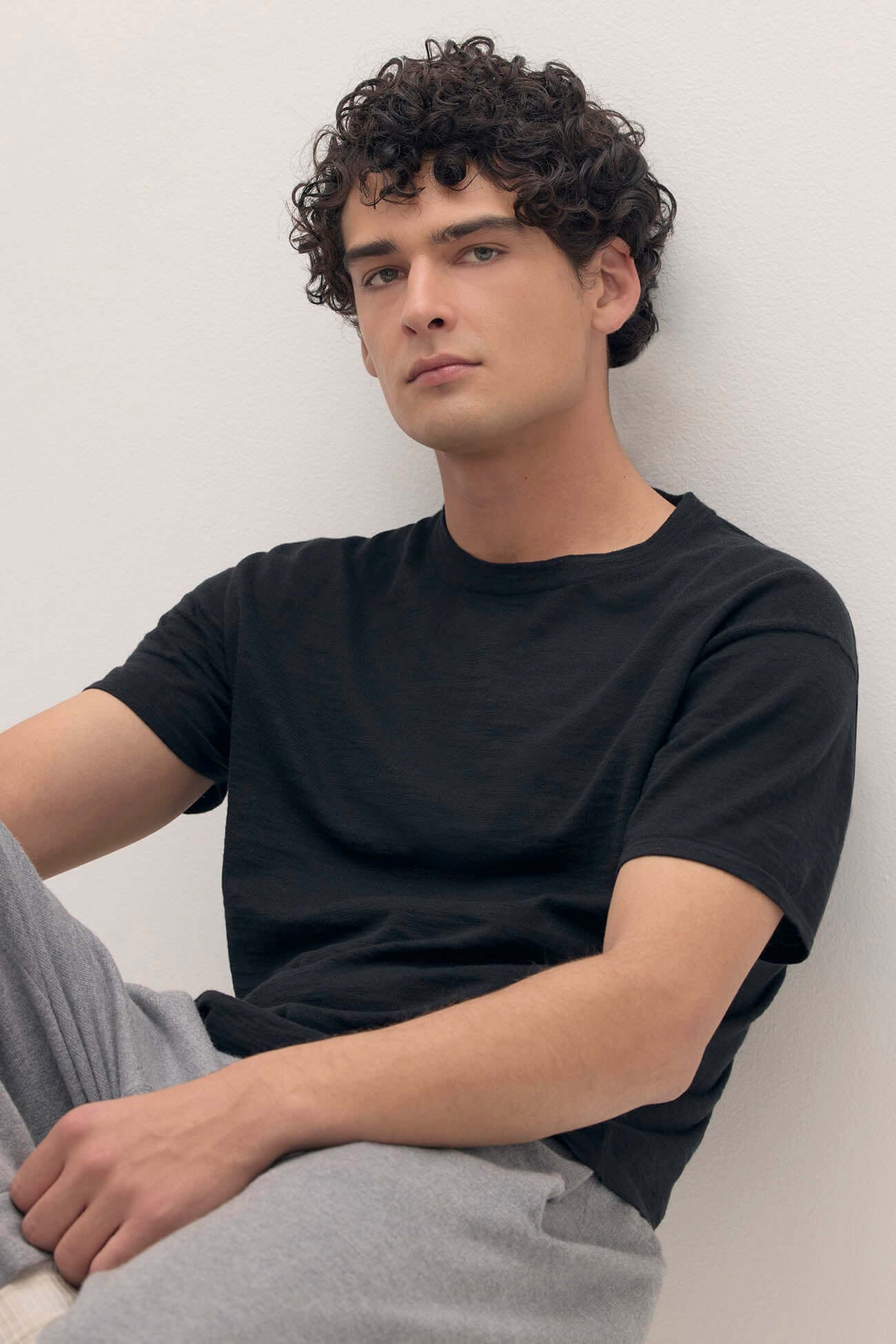 Model wearing comfortable black loungewear t-shirt and gray pants, showcasing a casual loungewear look.